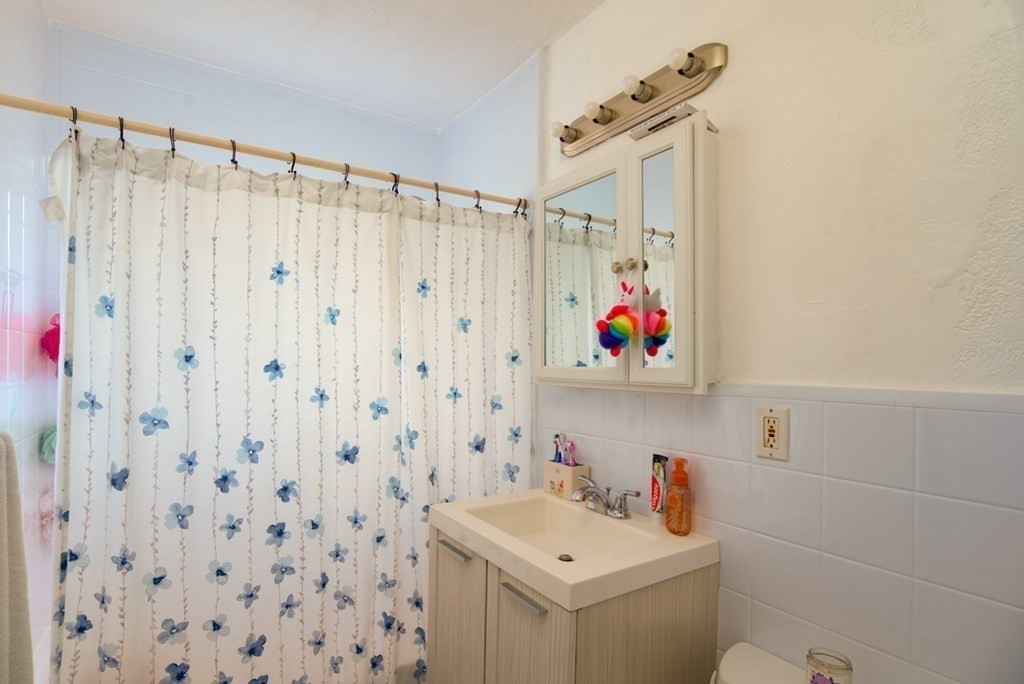 20 Westgate Road, Unit 4 Chestnut Hill, MA 02467 - Photo 7 of 16 a bathroom with a sink a vanity and a shower curtain