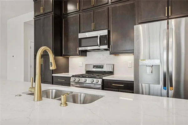 a kitchen with stainless steel appliances granite countertop a refrigerator and a stove top oven