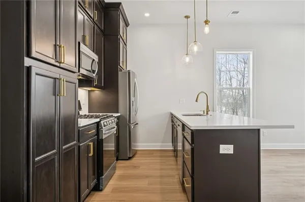 a kitchen with stainless steel appliances granite countertop a refrigerator a sink and a stove