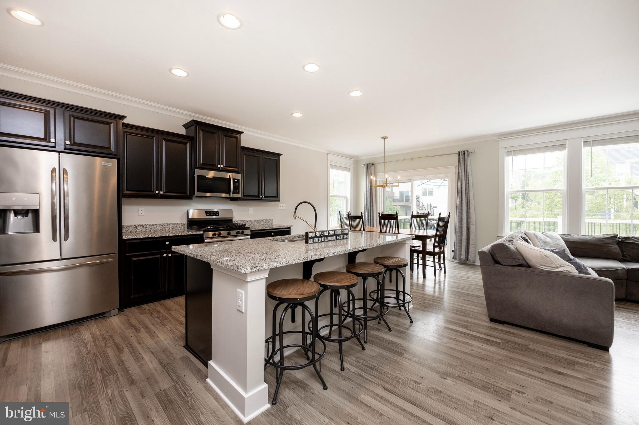 45 Nichols Mill Road Downingtown, PA 19335 - Photo 13 of 47 a kitchen with stainless steel appliances granite countertop a refrigerator a stove top oven a sink dishwasher a dining table and chairs with wooden floor