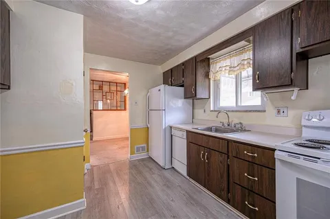 a kitchen with sink cabinets and wooden floor