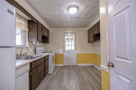a kitchen with a sink appliances and cabinets