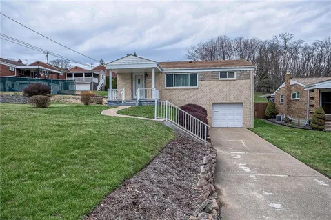 a front view of house with yard and green space