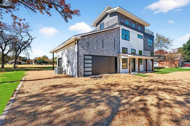 a front view of a house with a yard and potted plants