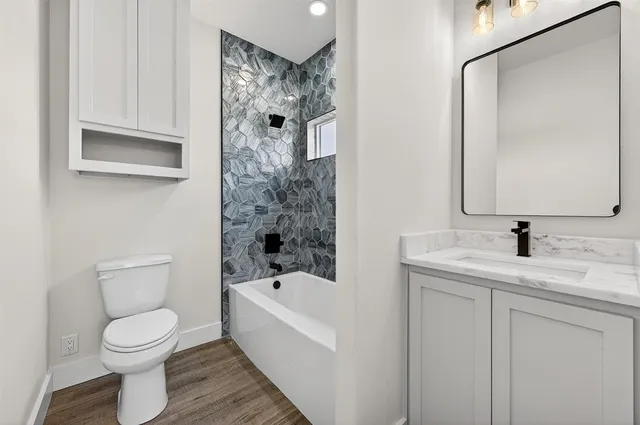 a view of a livingroom with wooden floor and a ceiling fan