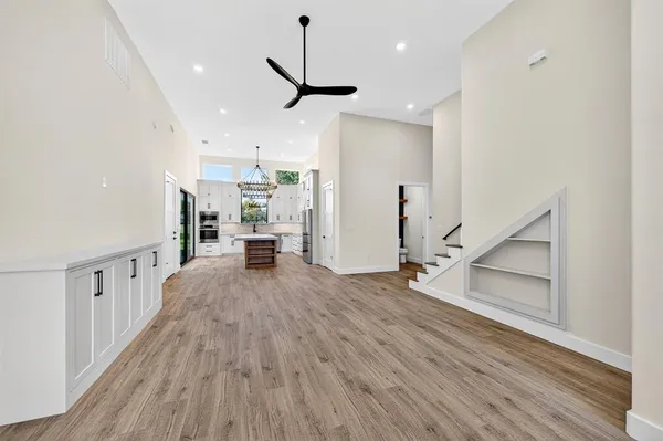 a view of a living room with wooden floor and stairs