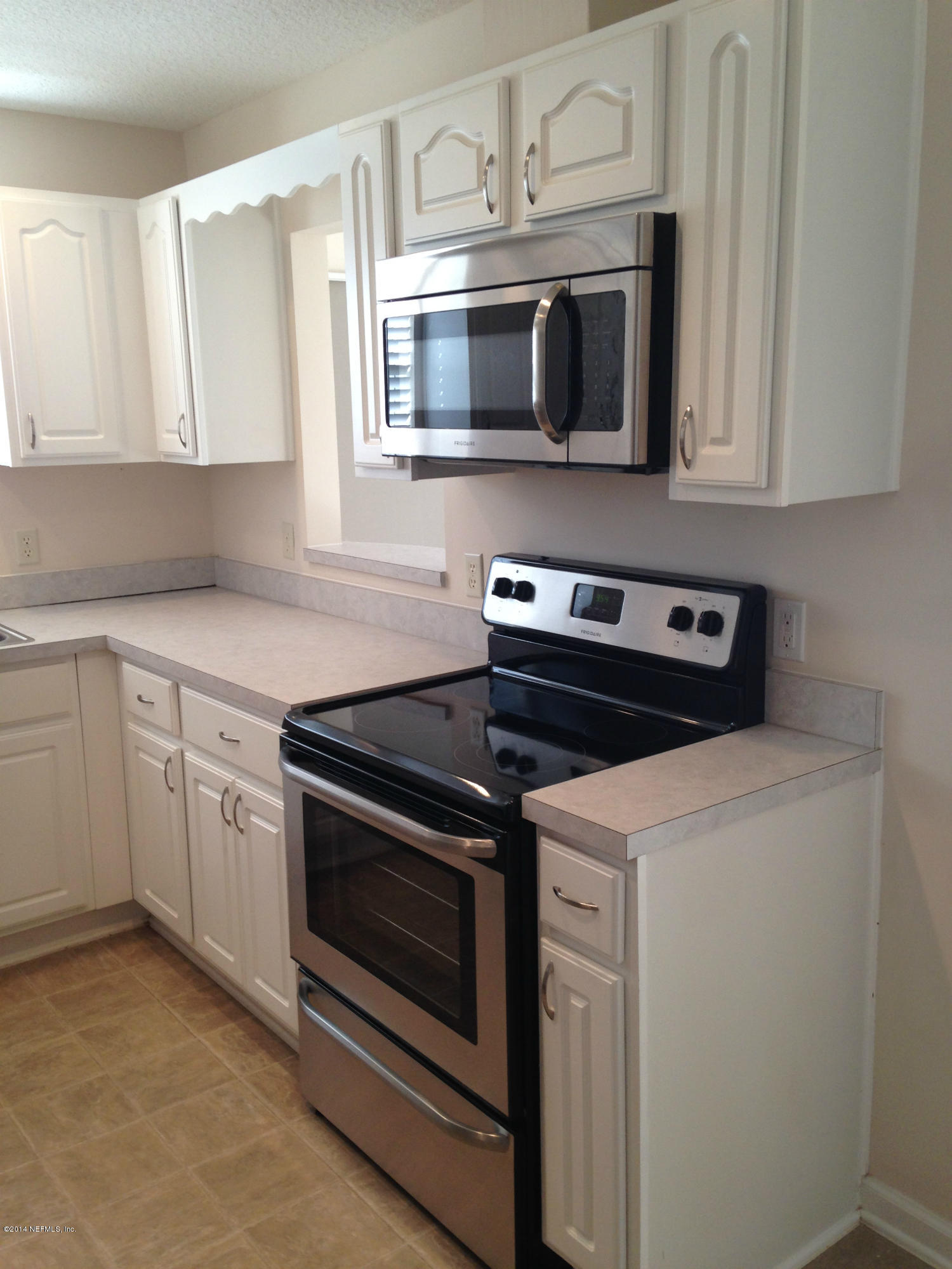 44206 Quail Rdg Drive Callahan, FL 32011 - Photo 3 of 17 a kitchen with stainless steel appliances white cabinets and stove top oven