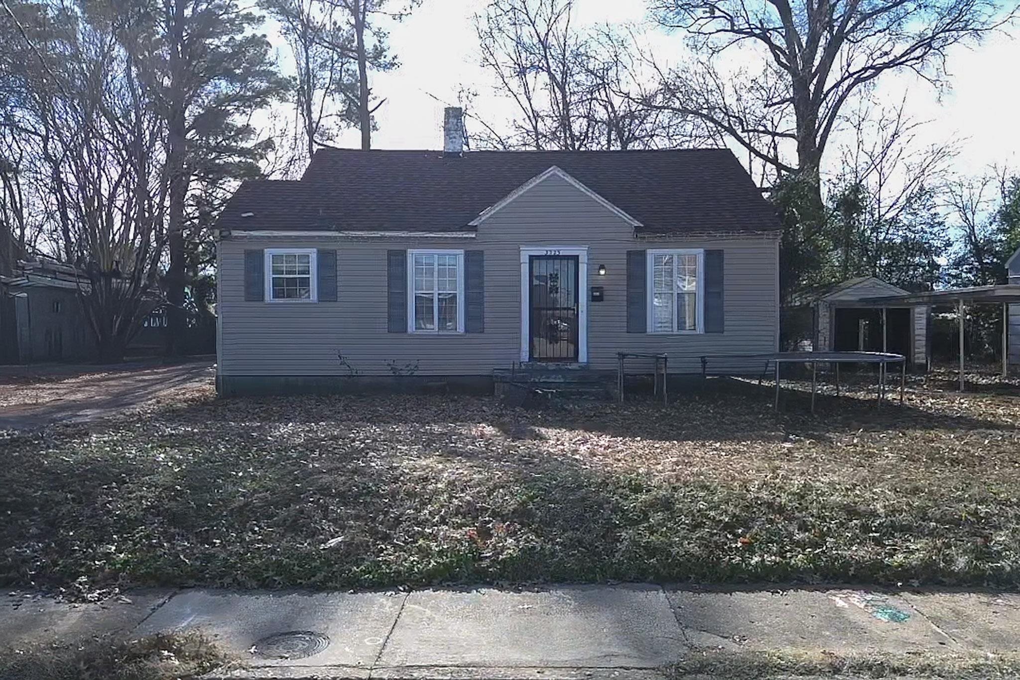 a front view of a house with a yard and trees