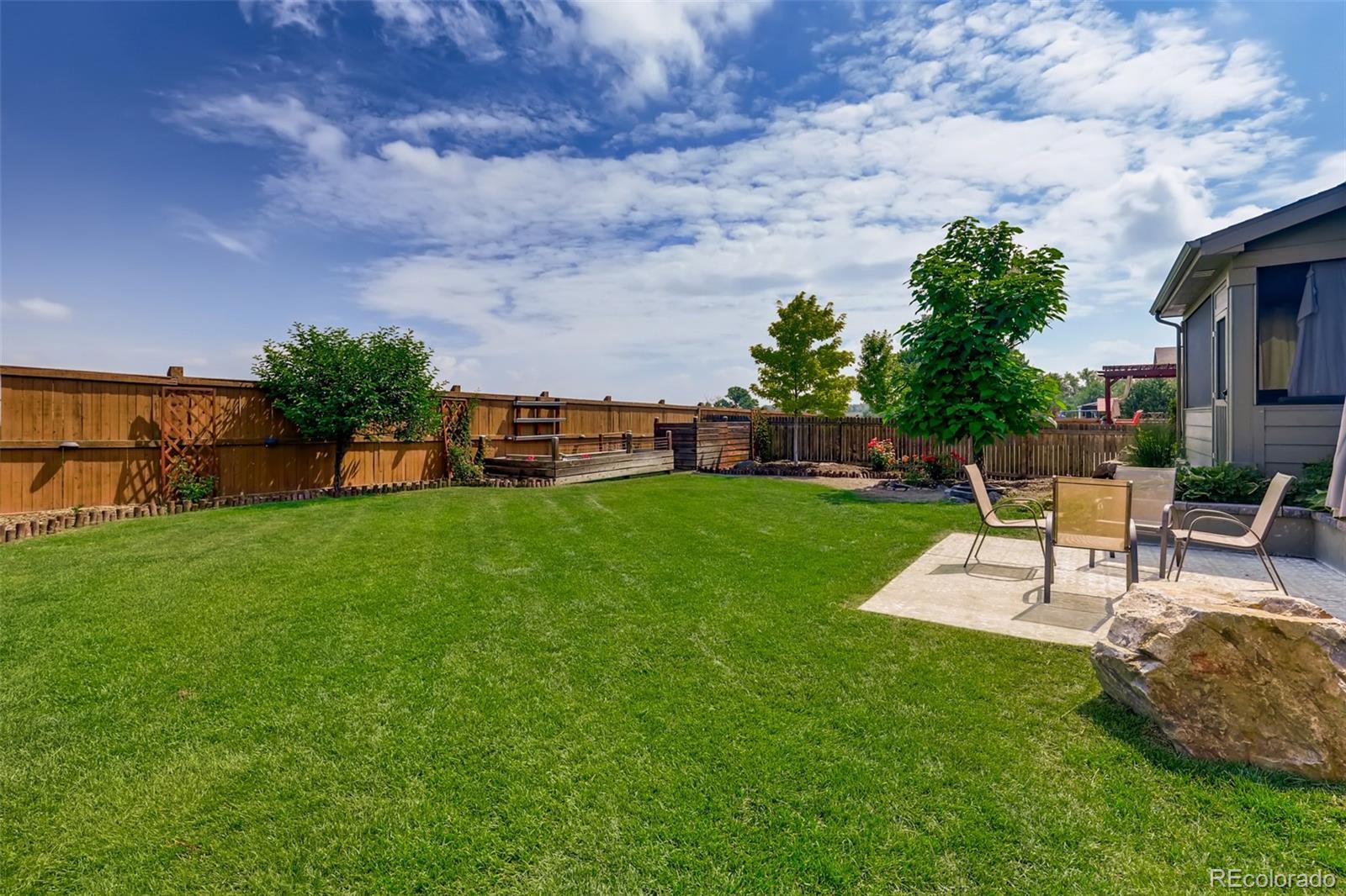 8537 Raspberry Drive Frederick, CO 80504 - Photo 28 of 31 a view of a garden with a bench