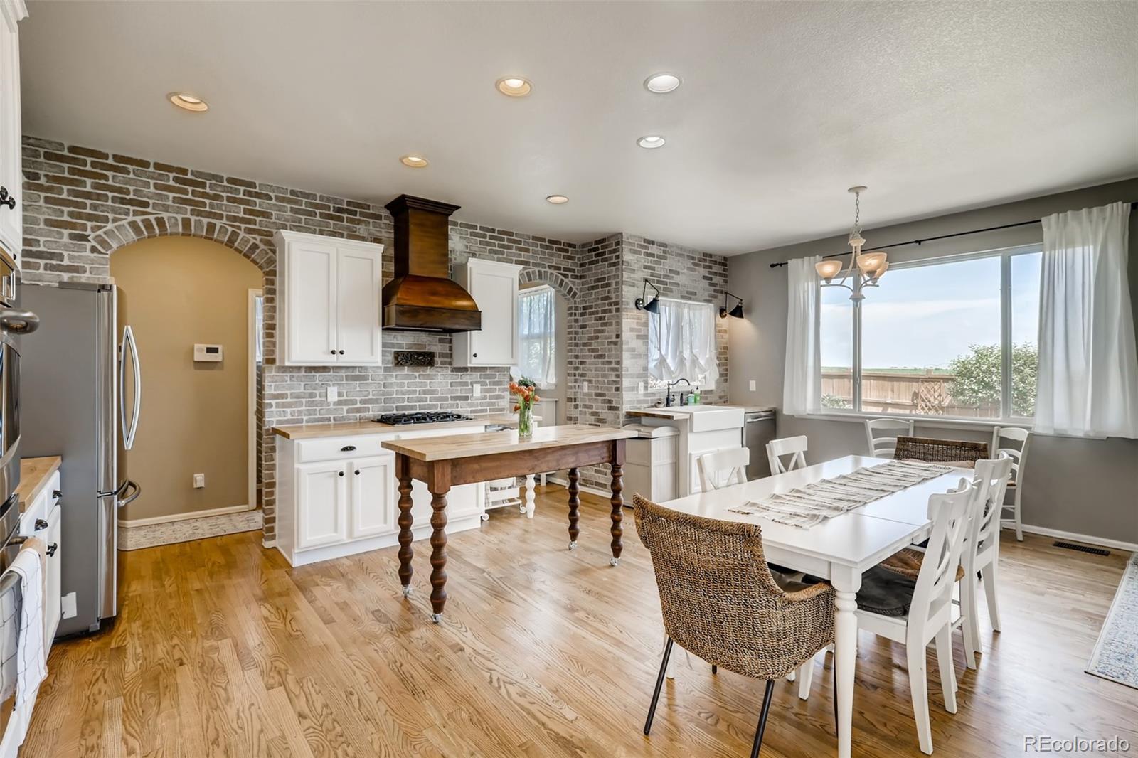 8537 Raspberry Drive Frederick, CO 80504 - Photo 5 of 31 a dining hall with stainless steel appliances kitchen island granite countertop a dining table chairs and window