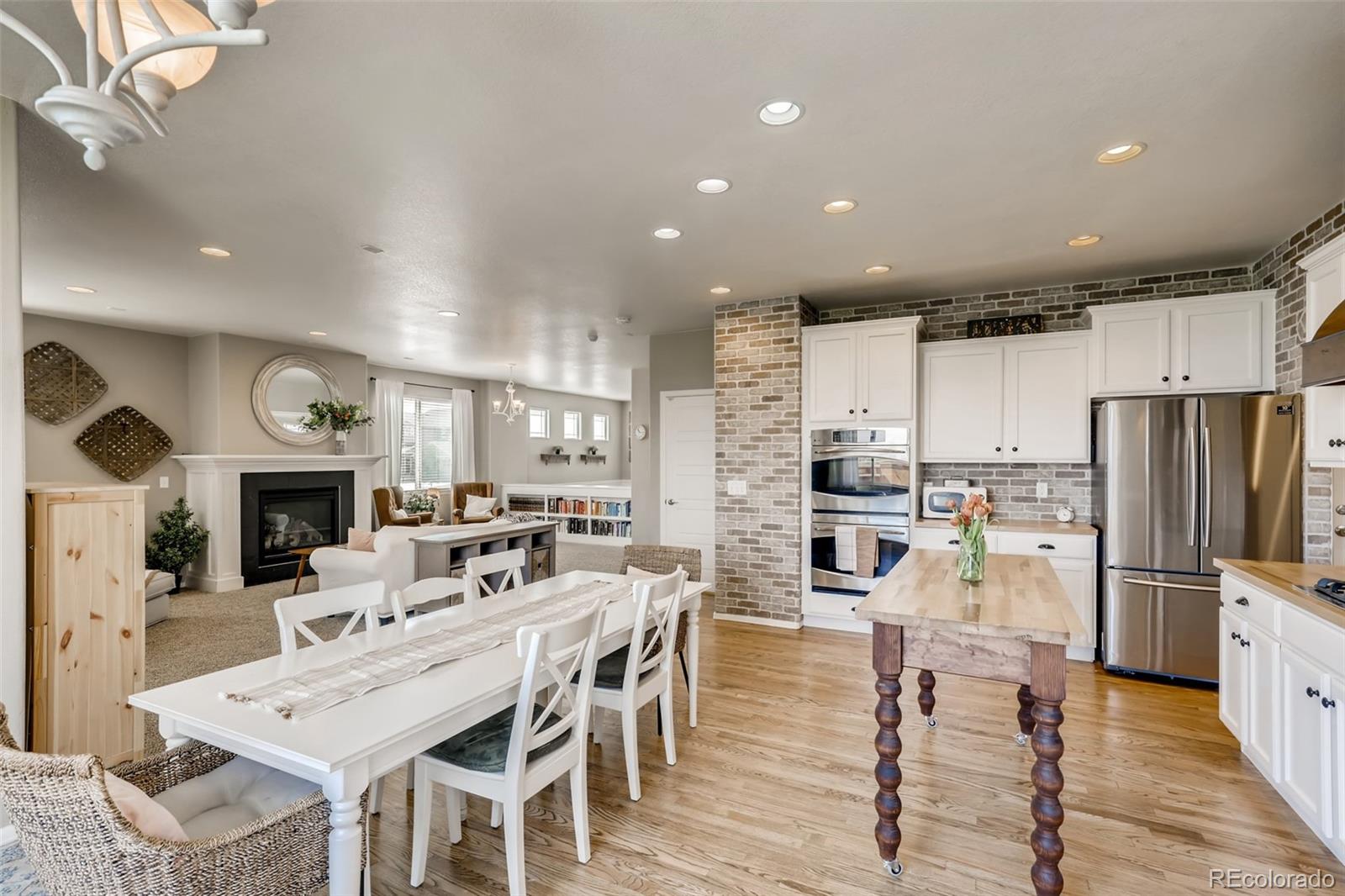 8537 Raspberry Drive Frederick, CO 80504 - Photo 8 of 31 a kitchen with stainless steel appliances kitchen island granite countertop a refrigerator a stove top oven a sink dishwasher and white cabinets with wooden floor
