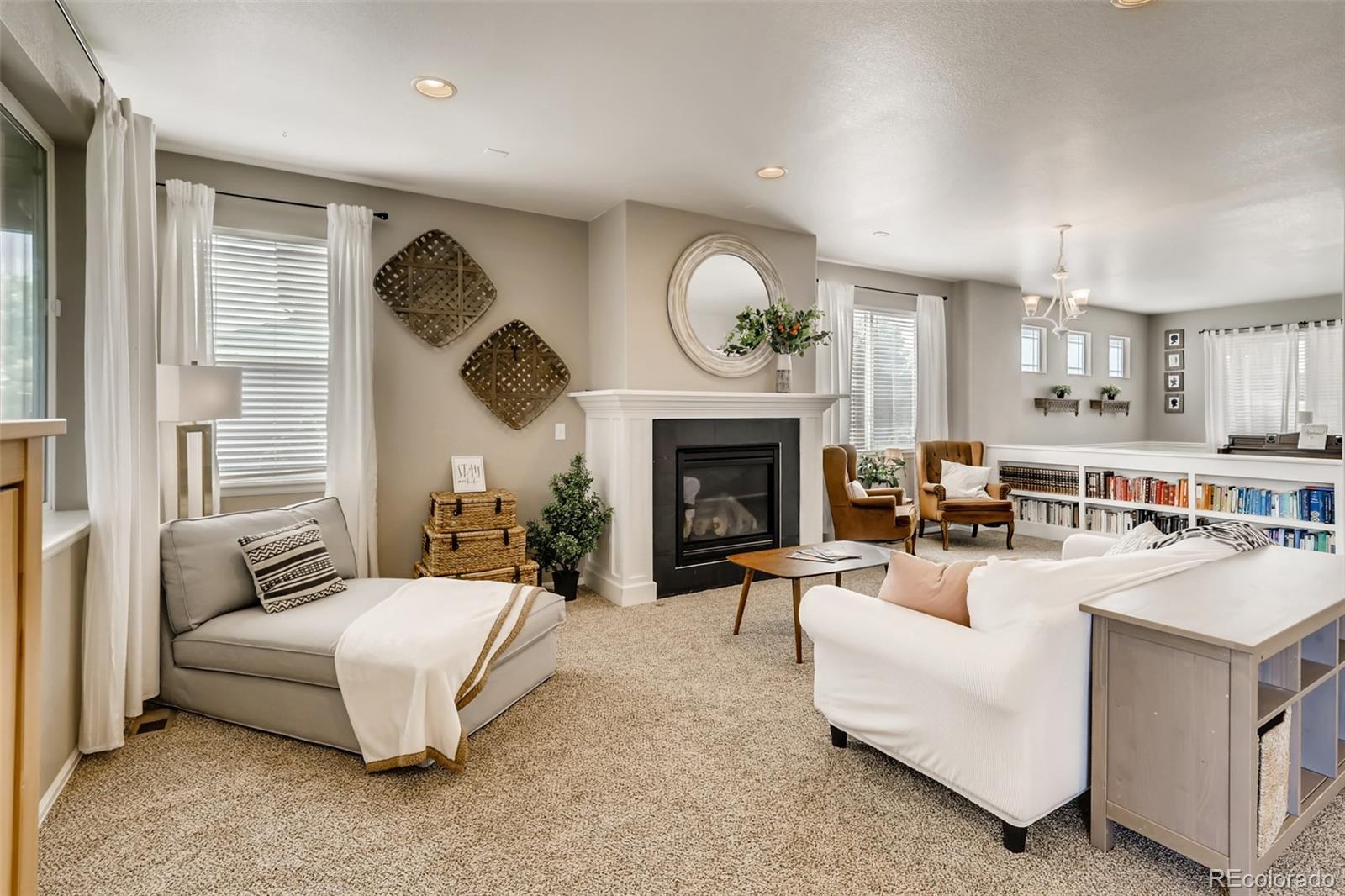 8537 Raspberry Drive Frederick, CO 80504 - Photo 9 of 31 a living room with furniture a fireplace and a large window