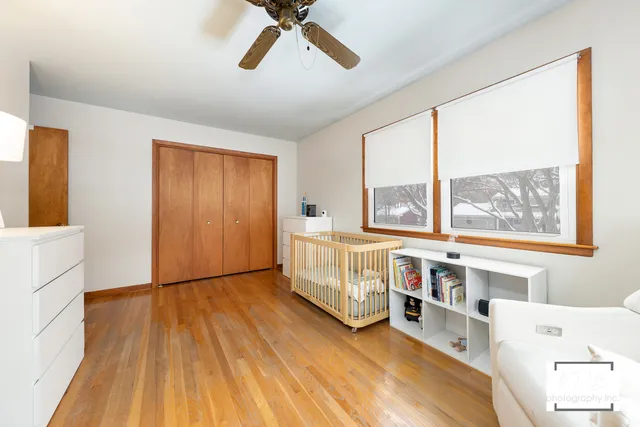 a view of a bedroom with baby bed and a window