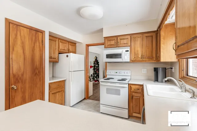 a kitchen with a refrigerator a stove top oven a sink and cabinets