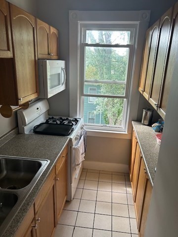516 Union Street, Unit 2 New Bedford, MA 02740 - Photo 7 of 11 a kitchen with a sink stove and cabinets