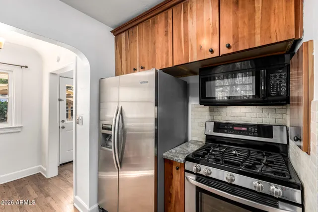 a kitchen with stainless steel appliances granite countertop a stove microwave and refrigerator