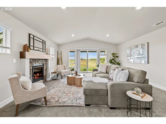 a living room with furniture a fireplace and a large window