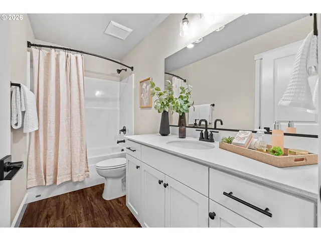 a bathroom with a double vanity sink toilet and shower