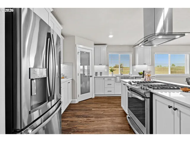 a kitchen with stainless steel appliances granite countertop a refrigerator a stove and a sink