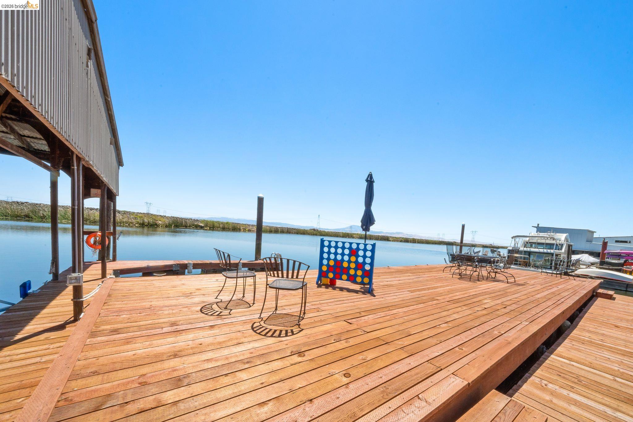 1704 Taylor Road Bethel Island, CA 94511 - Photo 49 of 73 Expansive waterfront deck featuring natural wood planks, a covered boat dock, and direct water access