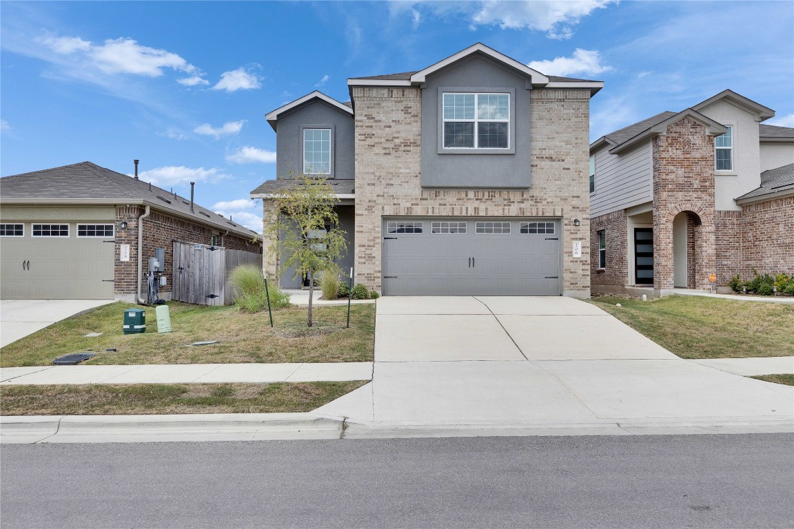 Front of home with covered entry and attached two car garage.