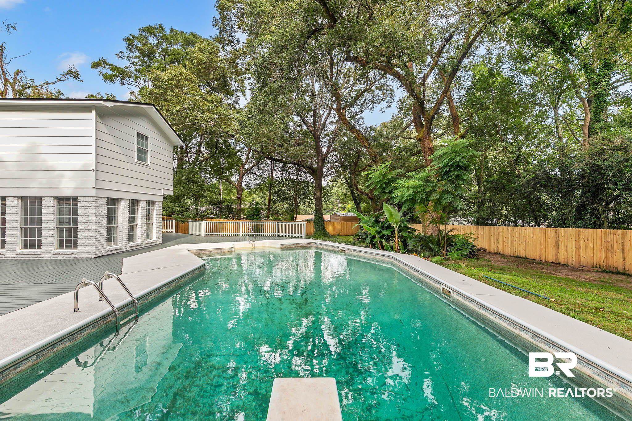 4705 Sherry Court Mobile, AL 36693 - Photo 64 of 100 View of swimming pool featuring a fenced backyard, a diving board, a patio area, and view of scattered trees