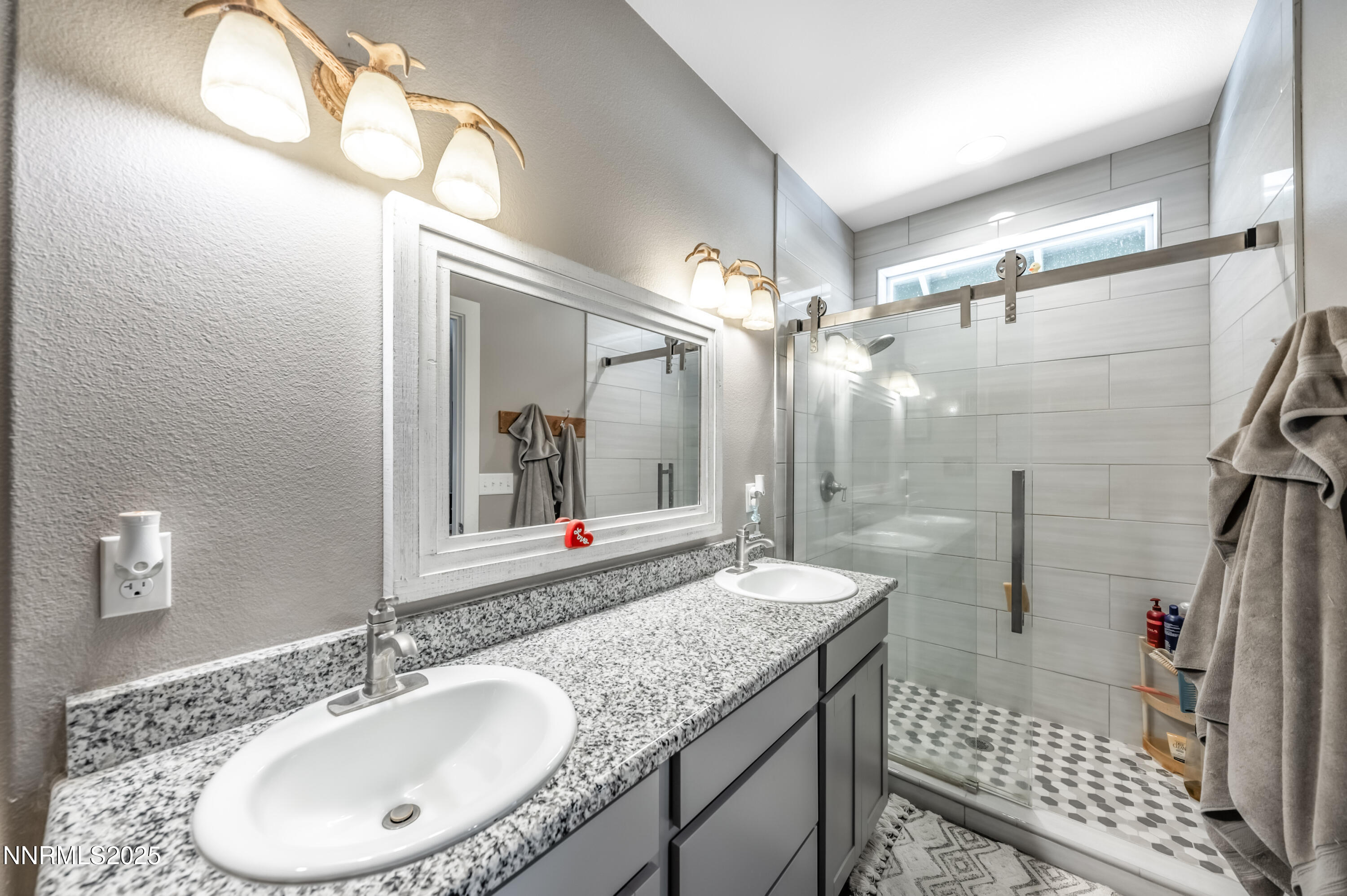 2486 Cartwright Road Reno, NV 89521 - Photo 17 of 44 a bathroom with a granite countertop sink a mirror and a shower