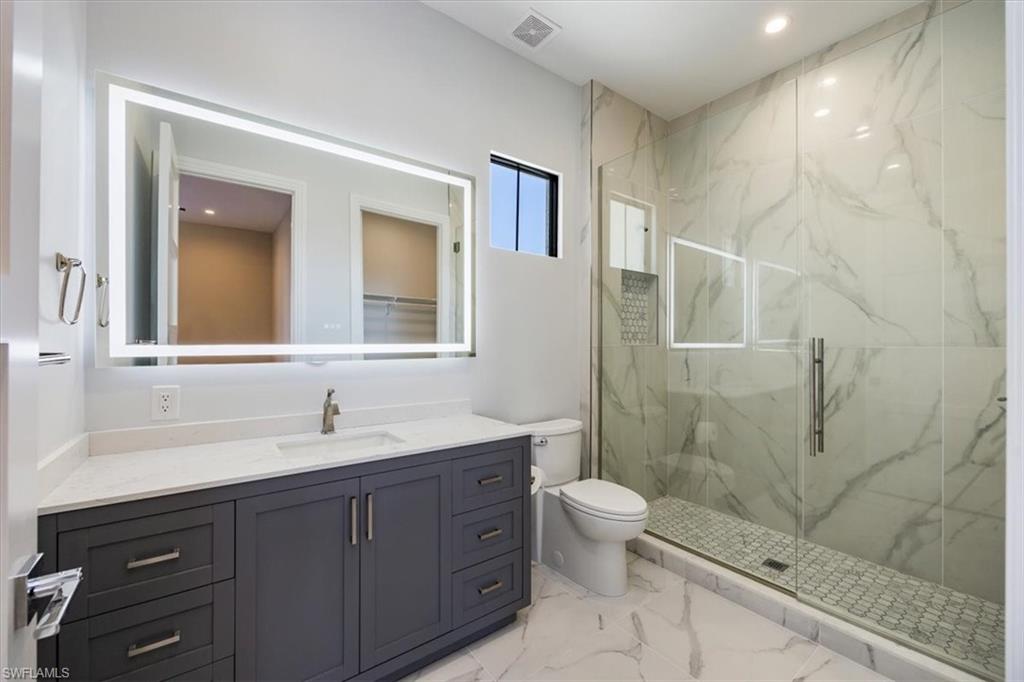 14211 Charthouse Circle Naples, FL 34114 - Photo 14 of 48 Full bath with a marble finish shower, vanity, light marble finish flooring, and recessed lighting