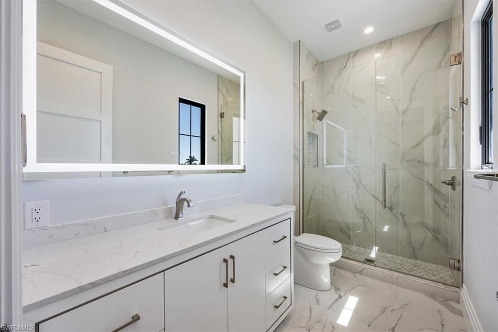 14211 Charthouse Circle Naples, FL 34114 - Photo 15 of 48 Full bathroom with vanity, a marble finish shower, light marble finish floors, and recessed lighting