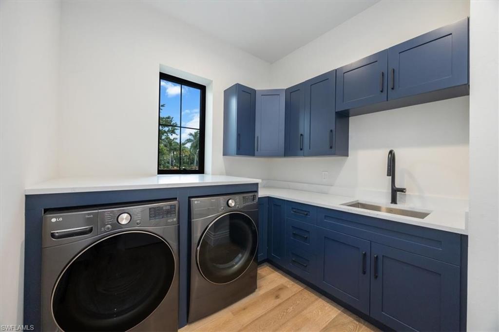 14211 Charthouse Circle Naples, FL 34114 - Photo 30 of 48 Washroom featuring light wood-type flooring, independent washer and dryer, and cabinet space