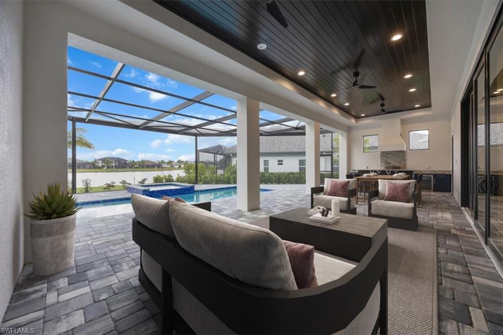 14211 Charthouse Circle Naples, FL 34114 - Photo 4 of 48 View of patio / terrace with an outdoor living space, a water view, a lanai, ceiling fan, and a pool with connected hot tub