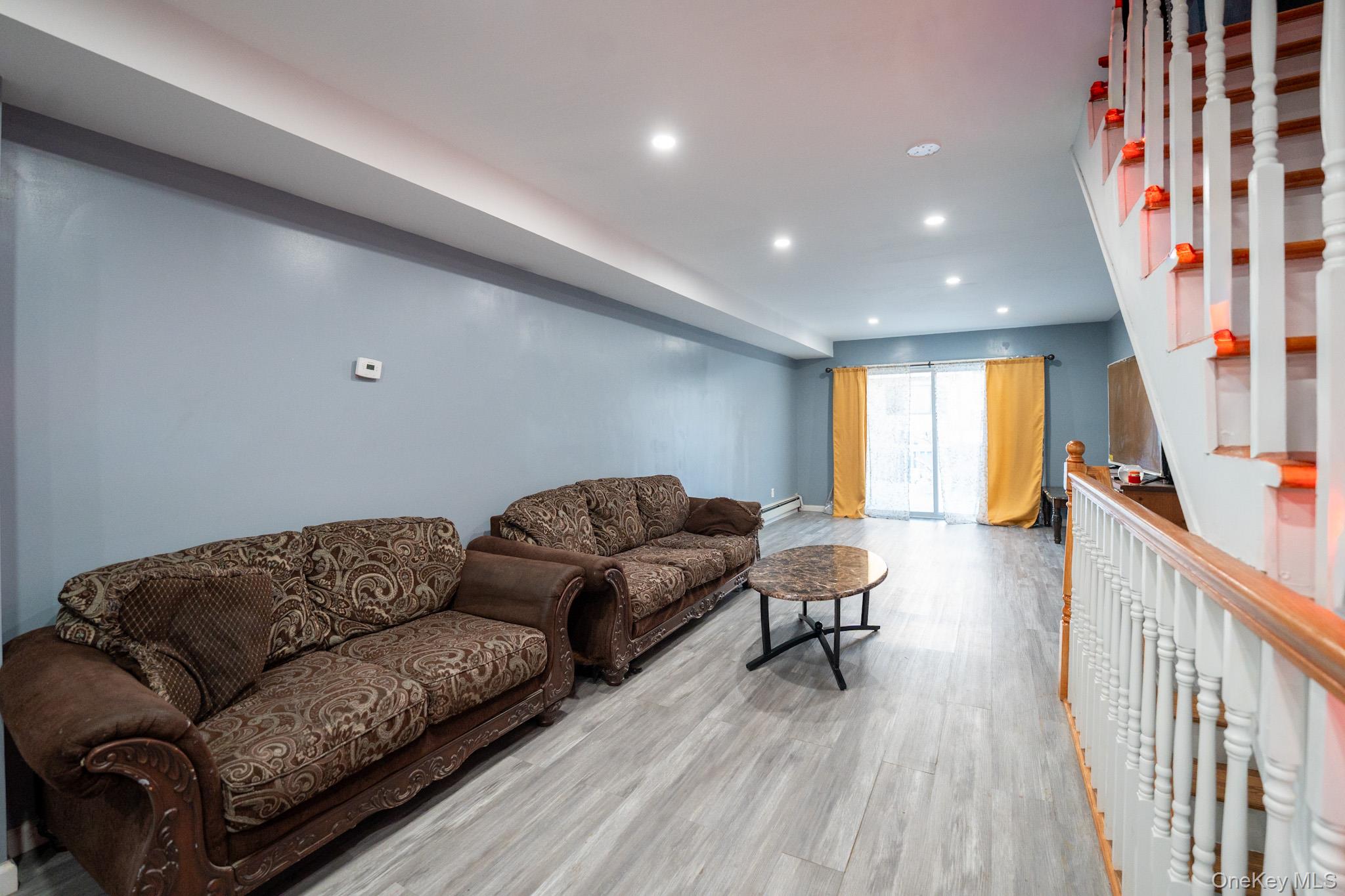 23 Yucca Drive Staten Island, NY 10312 - Photo 4 of 21 Living room with recessed lighting, stairway, wood finished floors, and a baseboard radiator