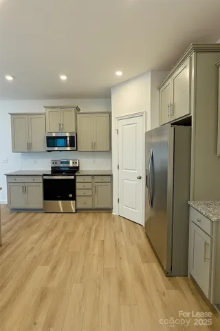 a kitchen with stainless steel appliances a refrigerator and a stove top oven