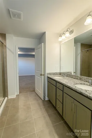 a bathroom with a granite countertop sink a mirror and a shower