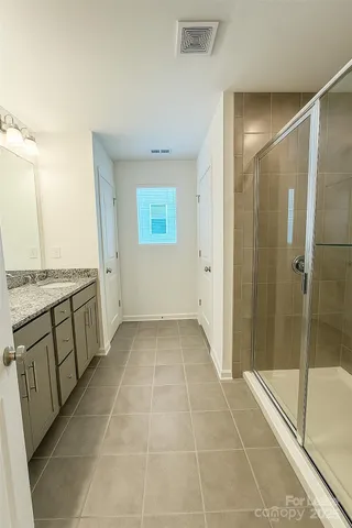 a bathroom with a granite countertop sink a toilet and a shower