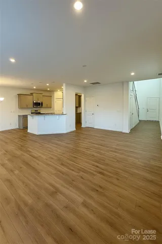 a view of a big room with wooden floor and windows