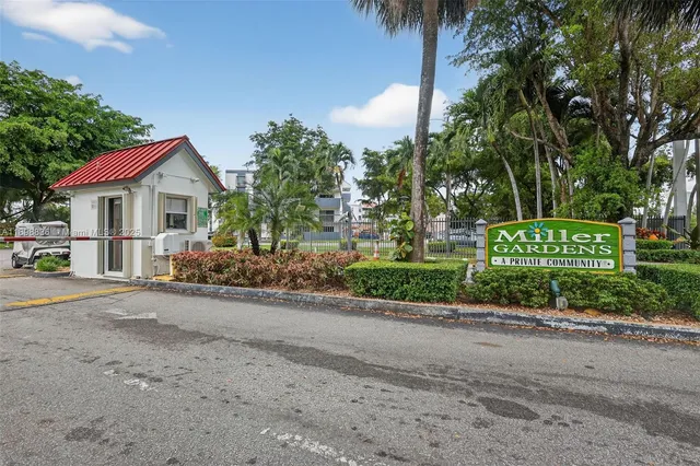 a front view of a house with a garden and trees