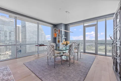 a dining room with furniture and large windows
