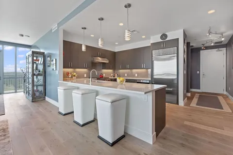 a kitchen with kitchen island a counter top space a sink stainless steel appliances and cabinets