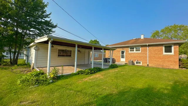 a view of a house with a yard and sitting area