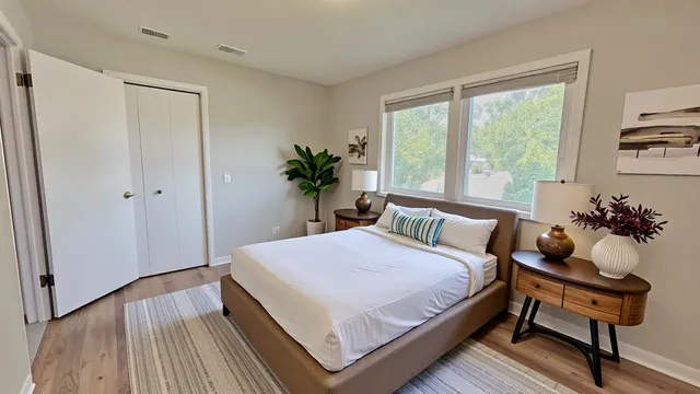 a bedroom with a bed table and a window