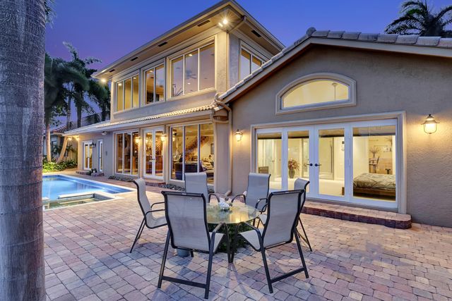 a view of swimming pool with a lounge chairs in front of a house