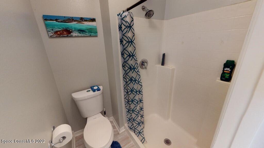 2343 Angel Road Palm Bay, FL 32909 - Photo 16 of 28 a white toilet sitting next to a shower curtain