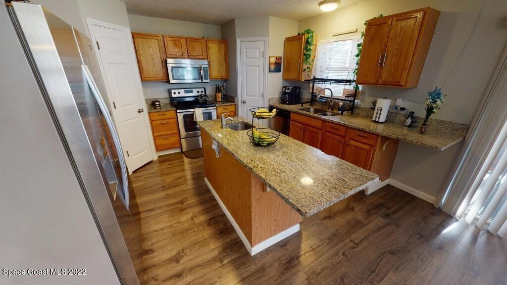 2343 Angel Road Palm Bay, FL 32909 - Photo 2 of 28 a kitchen with stainless steel appliances granite countertop sink stove and refrigerator