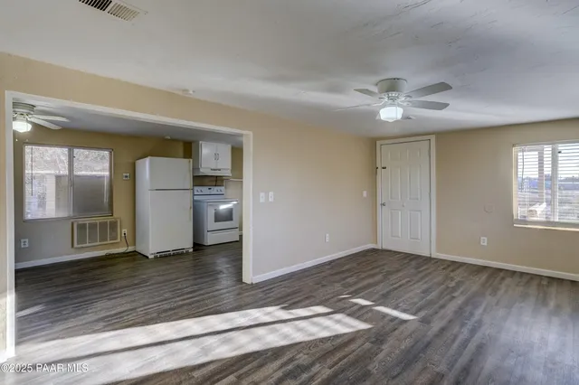 a view of empty room with wooden floor and window