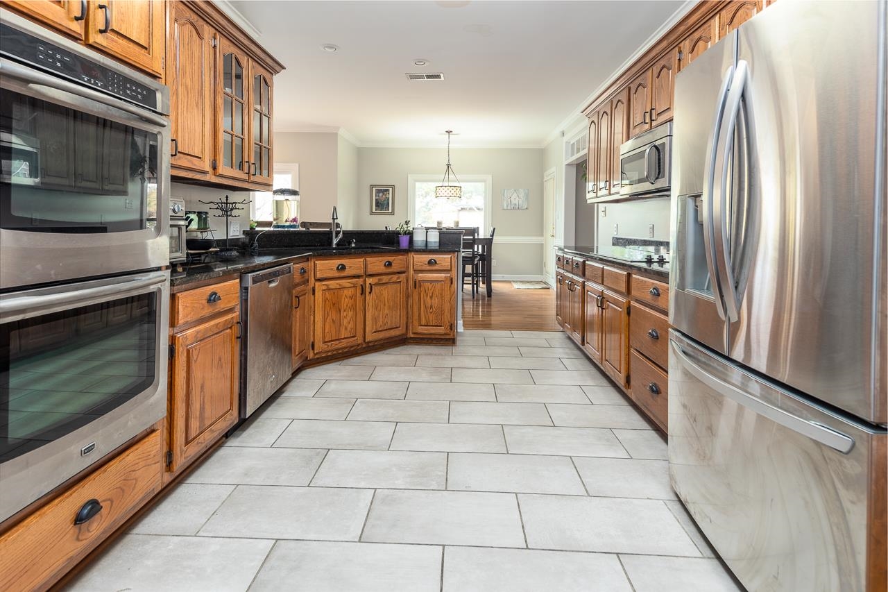 982 Handforth Cove Collierville, TN 38017 - Photo 12 of 25 a large kitchen with stainless steel appliances granite countertop a stove a sink and a microwave