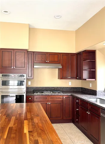 a kitchen with kitchen island granite countertop wooden cabinets and white appliances