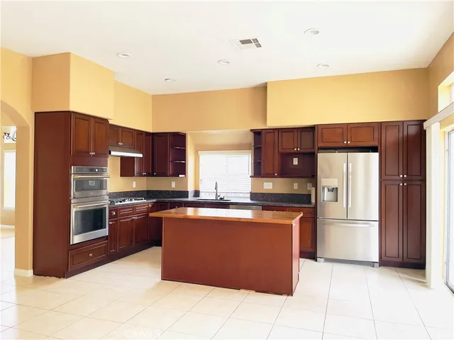 a kitchen with stainless steel appliances granite countertop a refrigerator and a stove