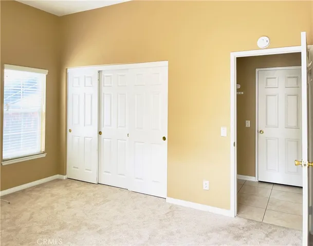 an empty room with windows and closet