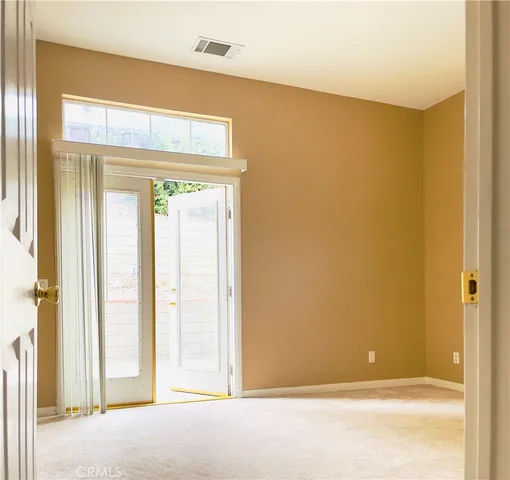 a view of a small space with wooden floor and a window